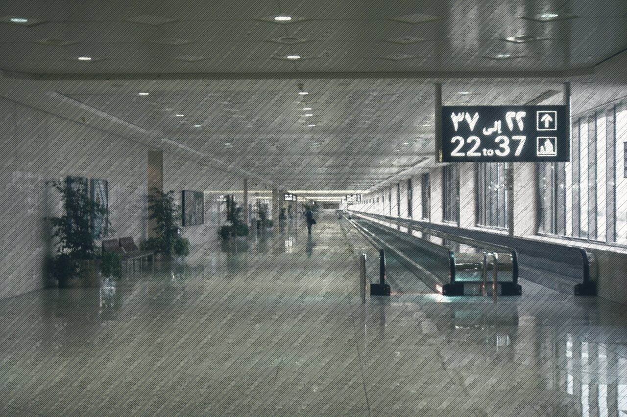 A long, empty concourse with moving walkways at King Fahd International Airport, Dammam
