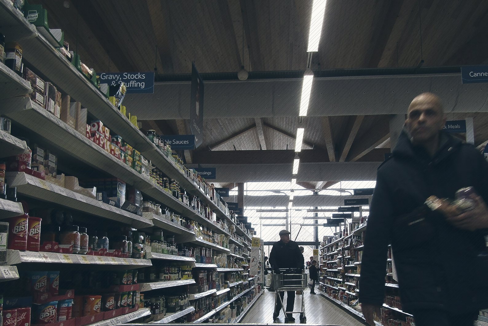 Shoppers in an aisle of packaged food at a British supermarket